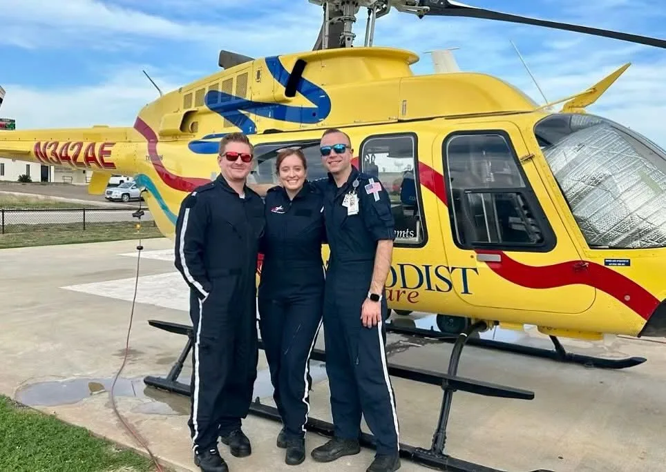 Tyler Butts with an air medical team beside a helicopter